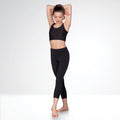 Woman wearing a black athletic outfit on a white background