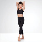 Woman wearing a black athletic outfit on a white background
