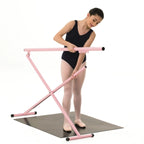 Ballerina using a pink ballet barre on a white background
