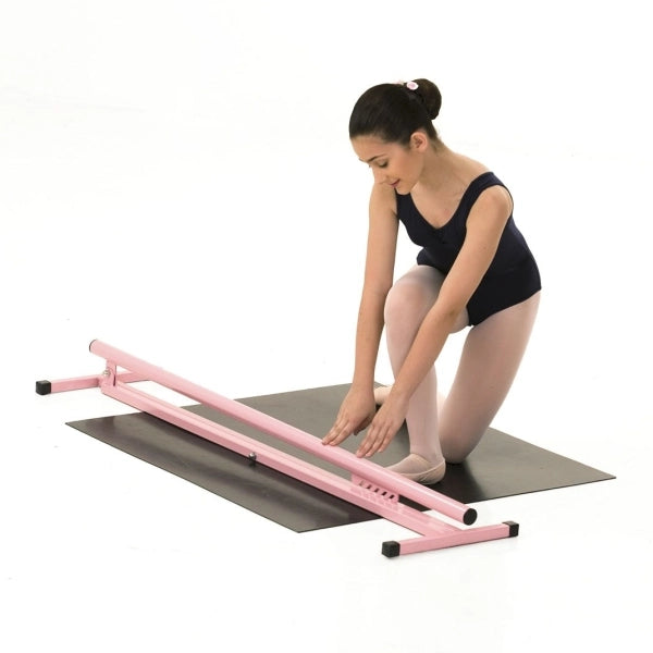 Woman using a pink ballet barre on a white background