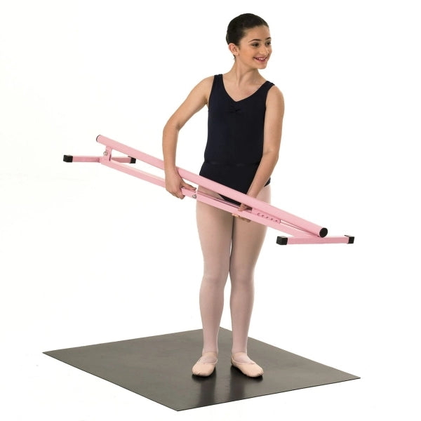 Young dancer holding a pink ballet barre on a white background