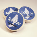 Three rolls of Bunheads Toe Tape on a light beige background