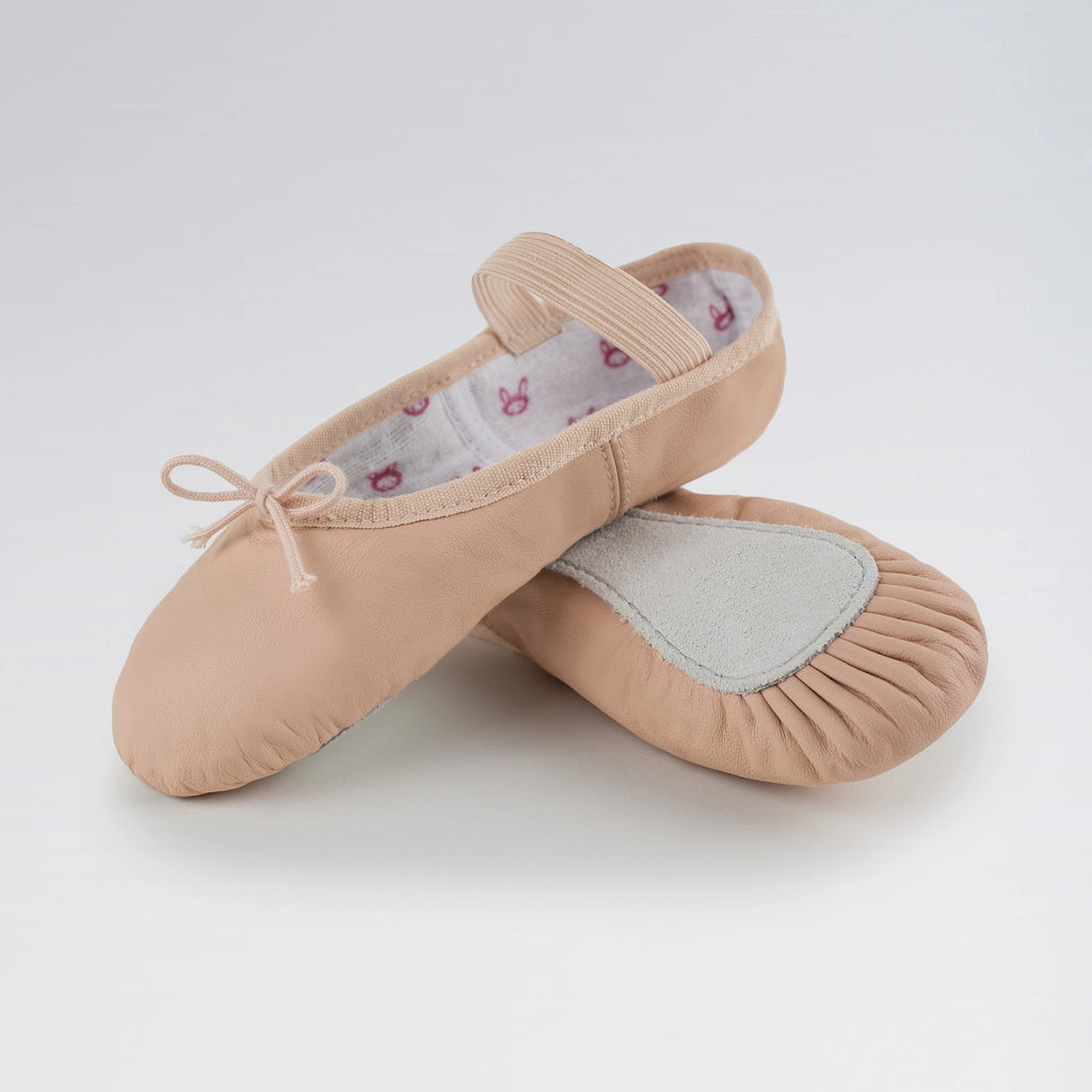 Pair of pink ballet slippers on a light gray background