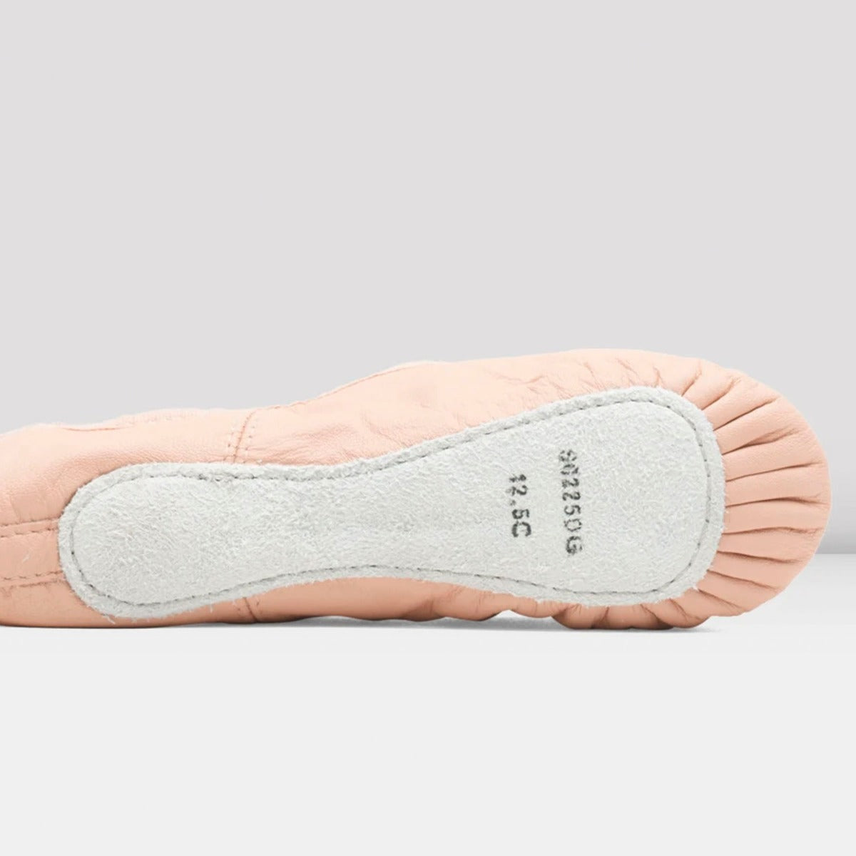 Close-up of a ballet shoe with a light gray sole on a white background