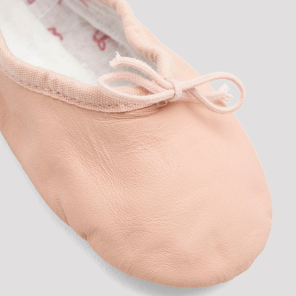 Close-up of a pink ballet shoe on a light gray background