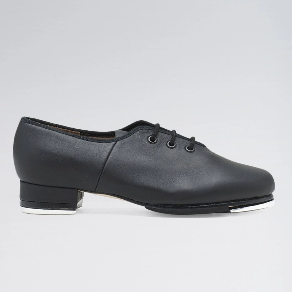 Black tap dance shoe on a gray background