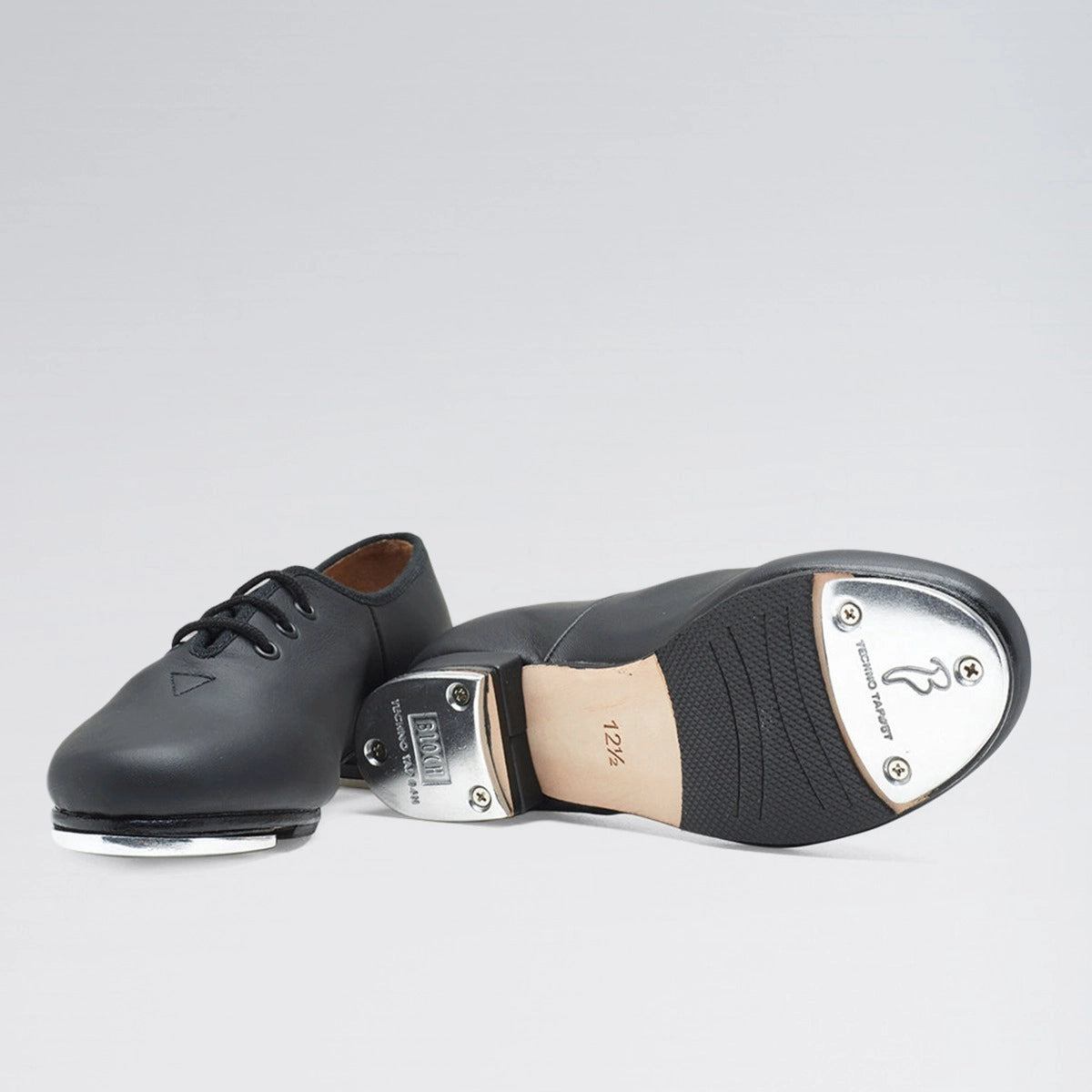 Black tap dance shoe with metallic toe on a white background
