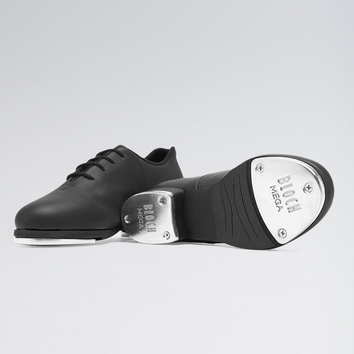 Black tap dance shoe with metallic toe on a light gray background
