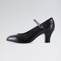 Black shoe with a strap on a light gray background