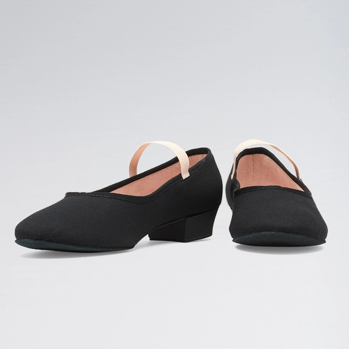 Pair of black dance shoes with a small heel on a light gray background