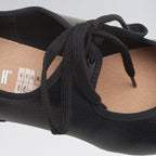 Black ballet flats with laces on a white background