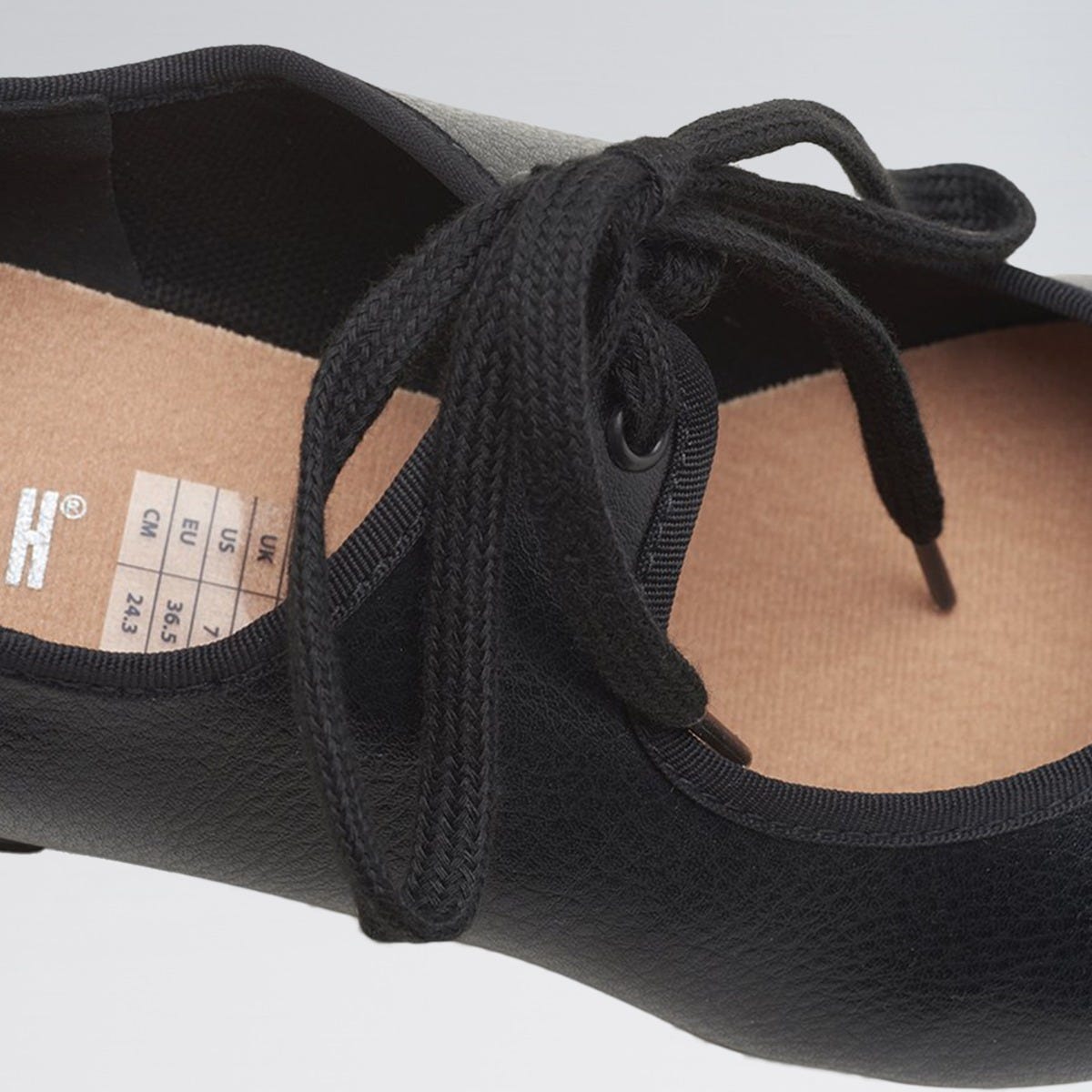 Black ballet flats with laces on a white background