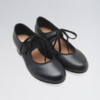 Pair of black leather shoes with laces on a light gray background
