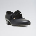 Black tap dance shoe with a small heel and metal tap on a light gray background