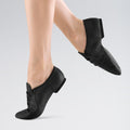 Black jazz shoes worn by a person on a light grey background