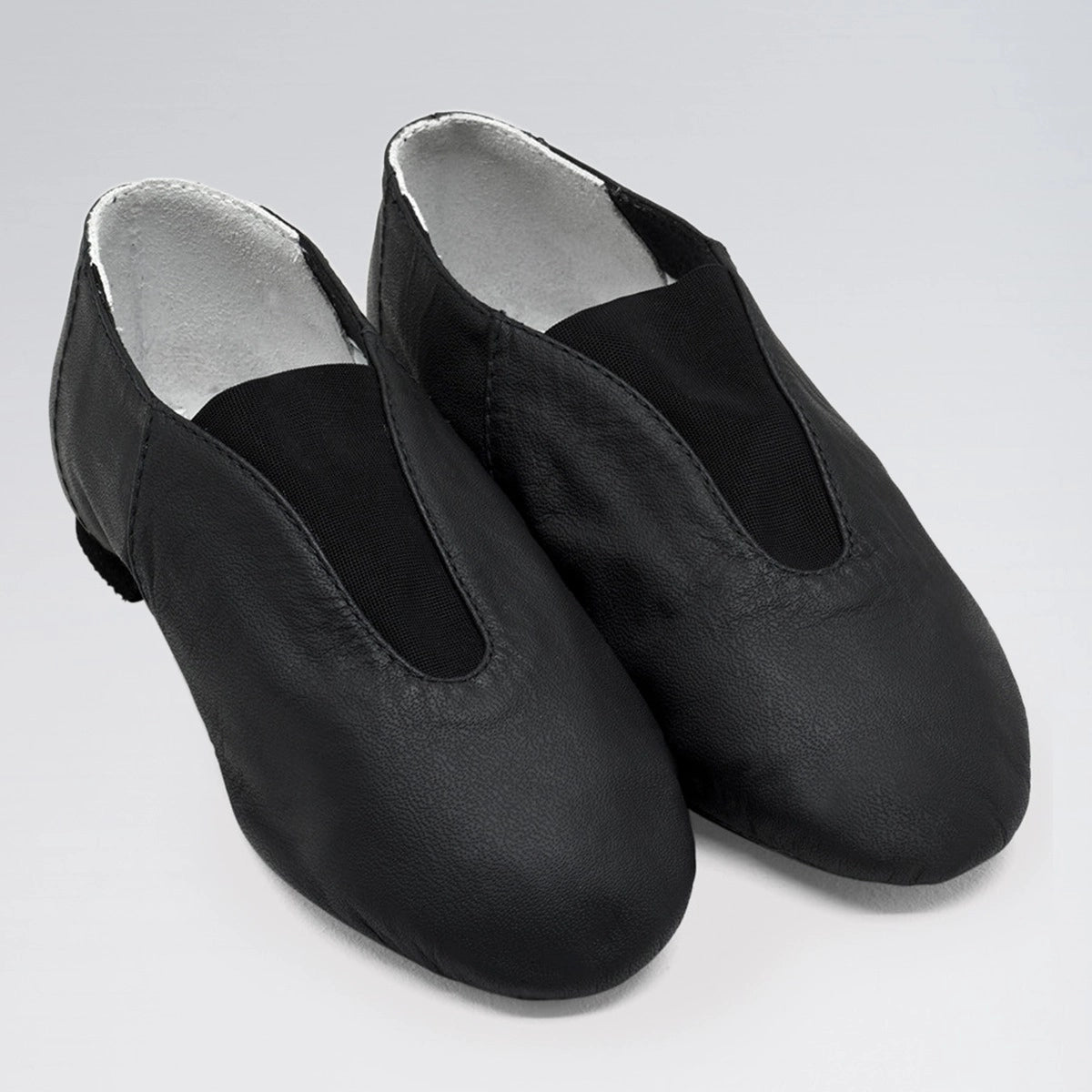 Pair of black dance shoes with silver lining on a light gray background