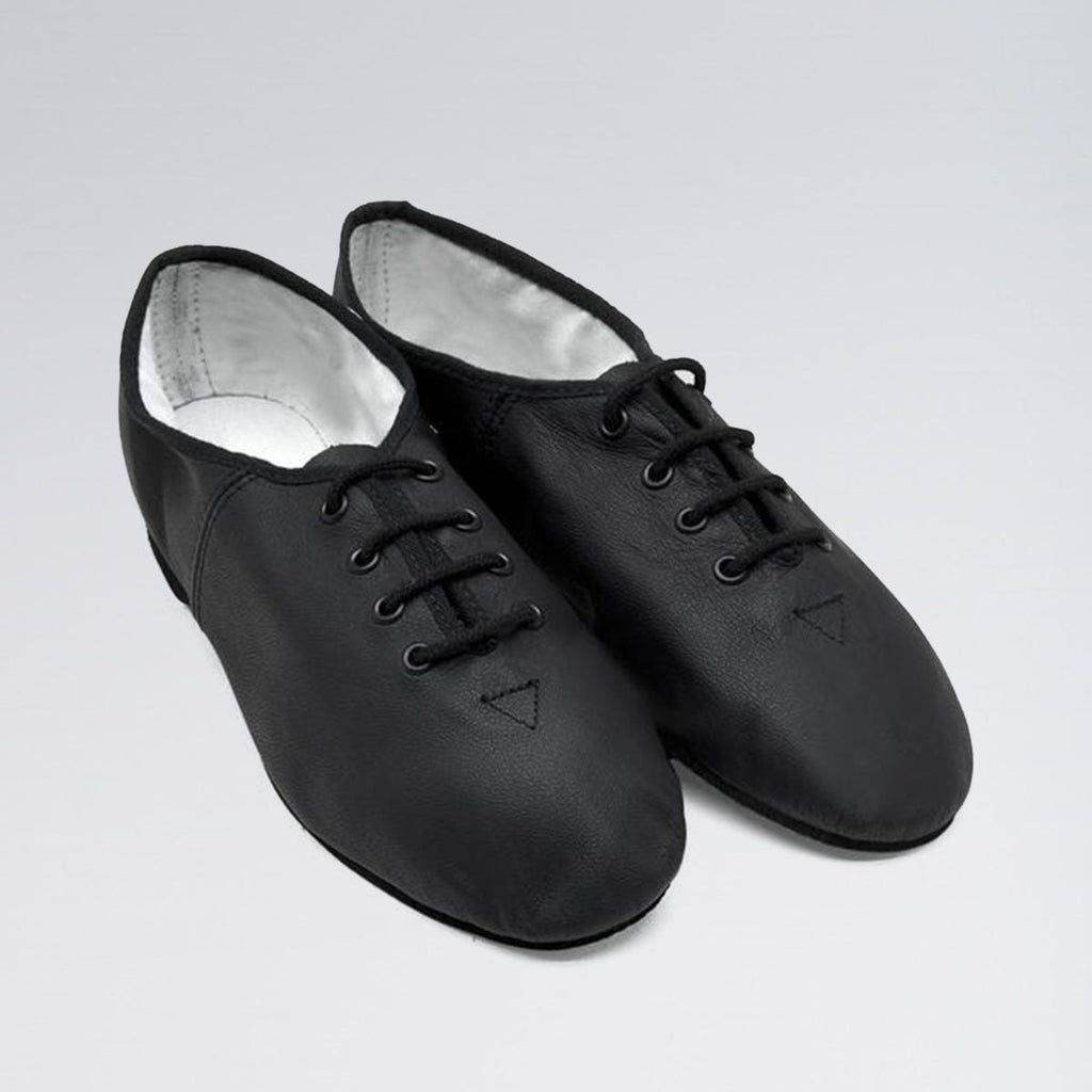 Pair of black dance shoes on a light gray background
