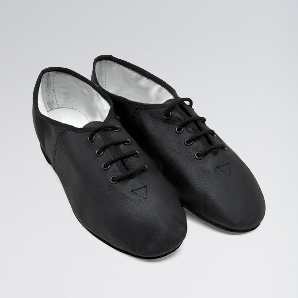 Pair of black dance shoes on a light gray background