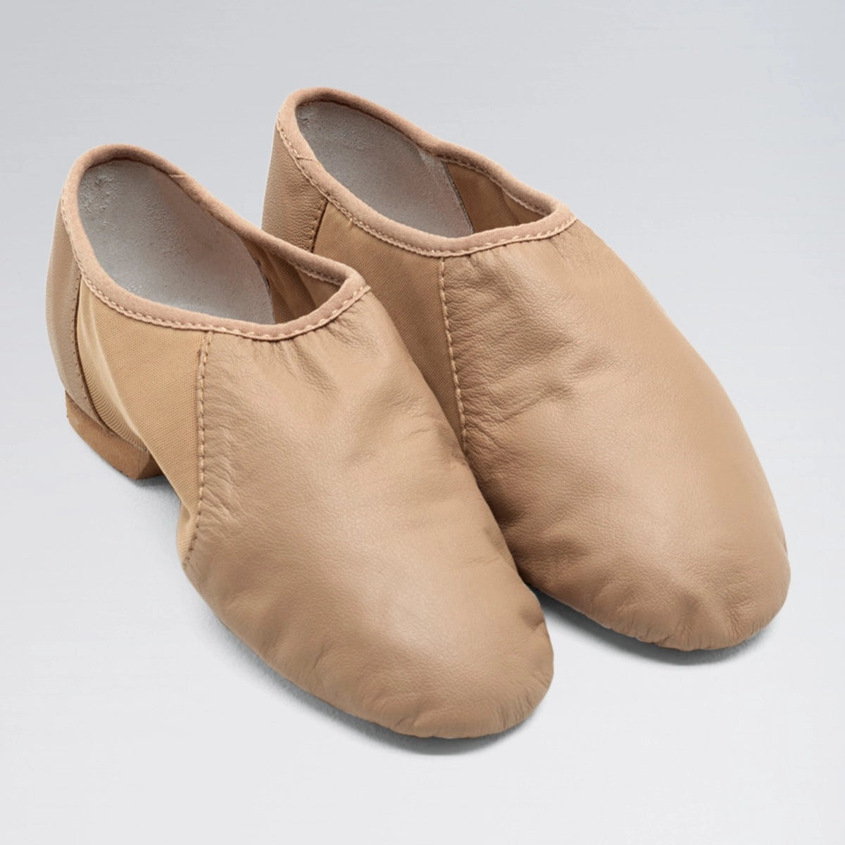 Pair of beige dance shoes on a light gray background
