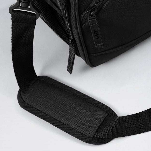 Black backpack with a shoulder strap on a light gray background