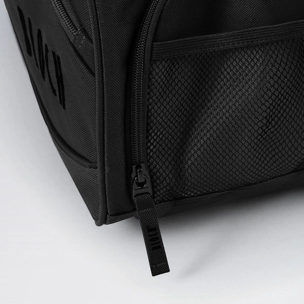 Close-up of a black backpack with zipper details on a light gray background