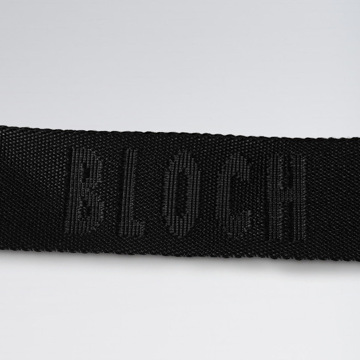 Black belt with a brand logo on a light gray background