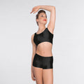 Woman wearing a black one-shoulder top and black shorts on a white background