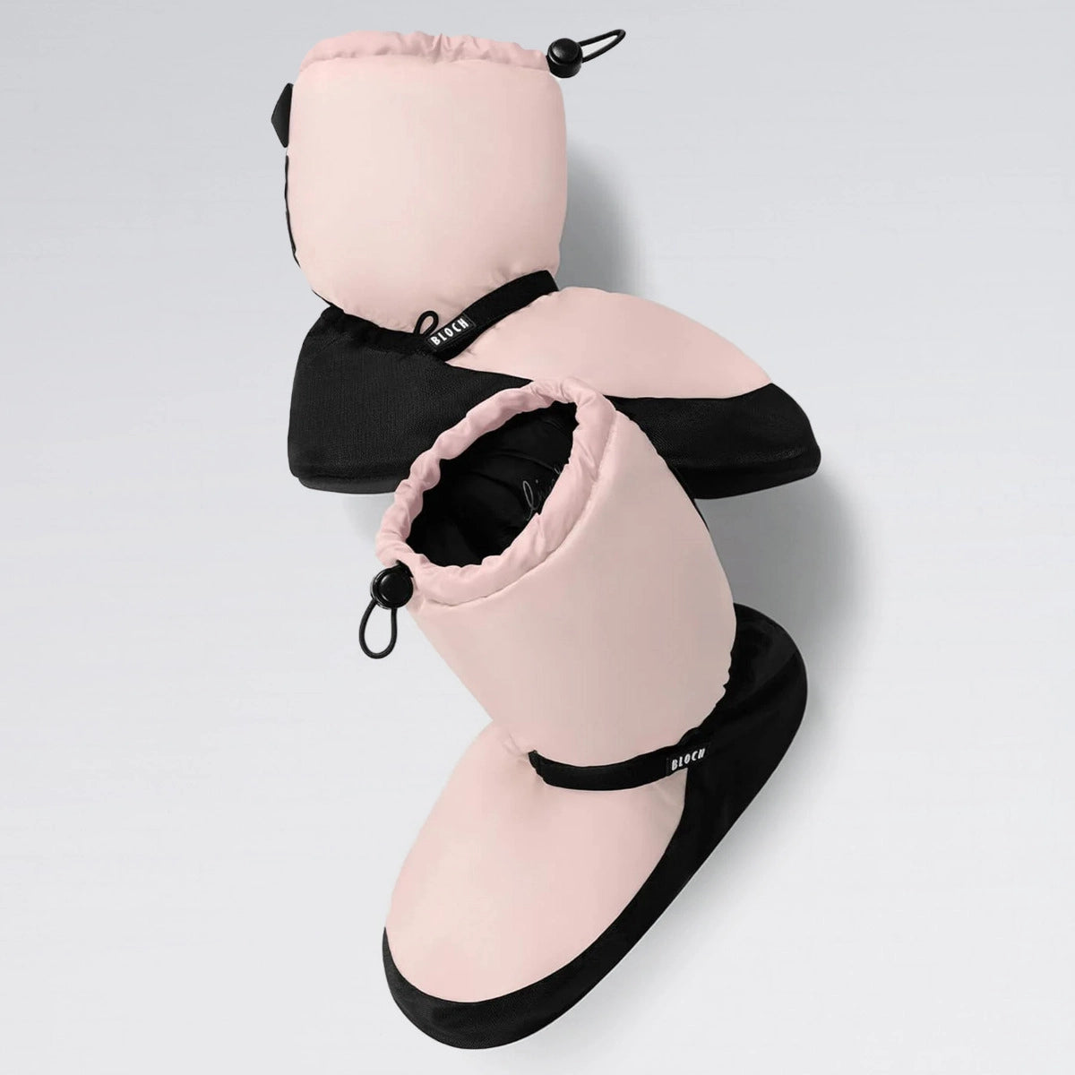 Pair of pink and black slippers with drawstring on a light gray background