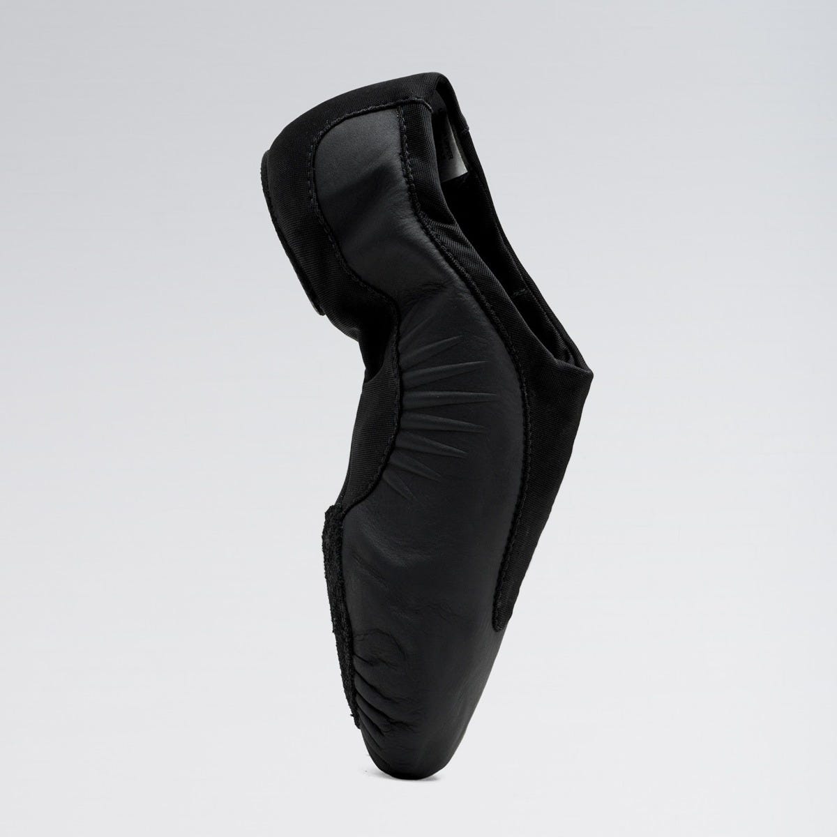 Black ballet shoe on a light gray background