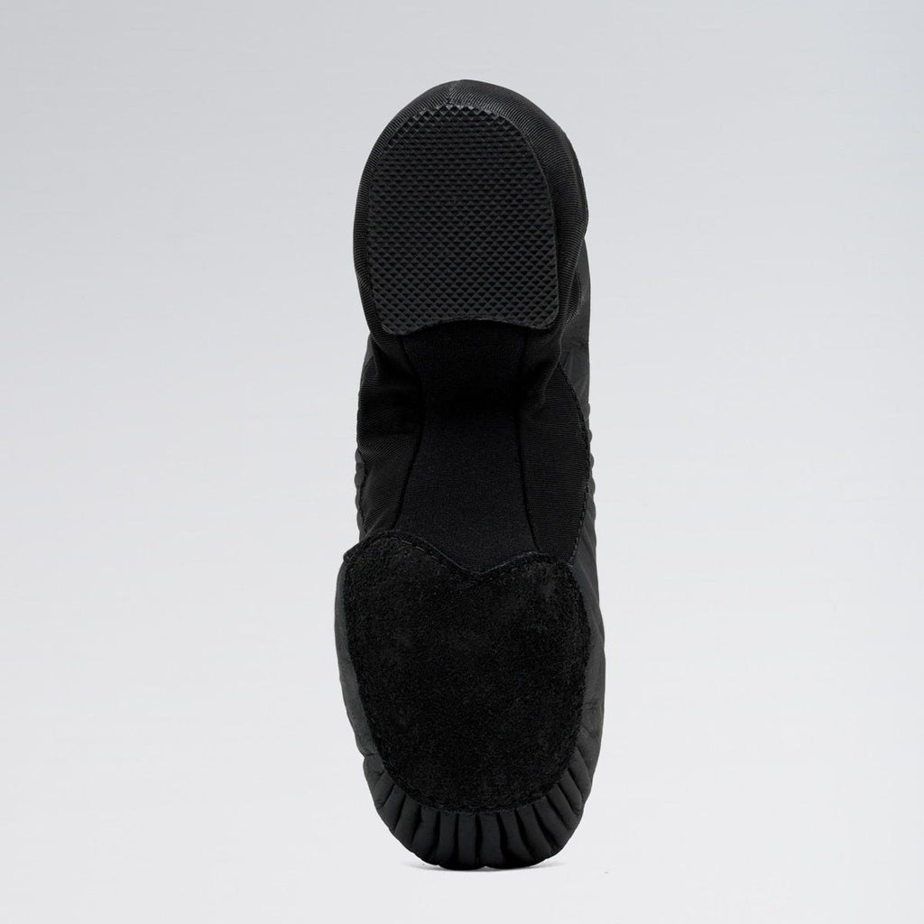 Black slip-on shoe with textured sole on a light gray background