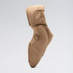 Tan ballet shoe on a light gray background