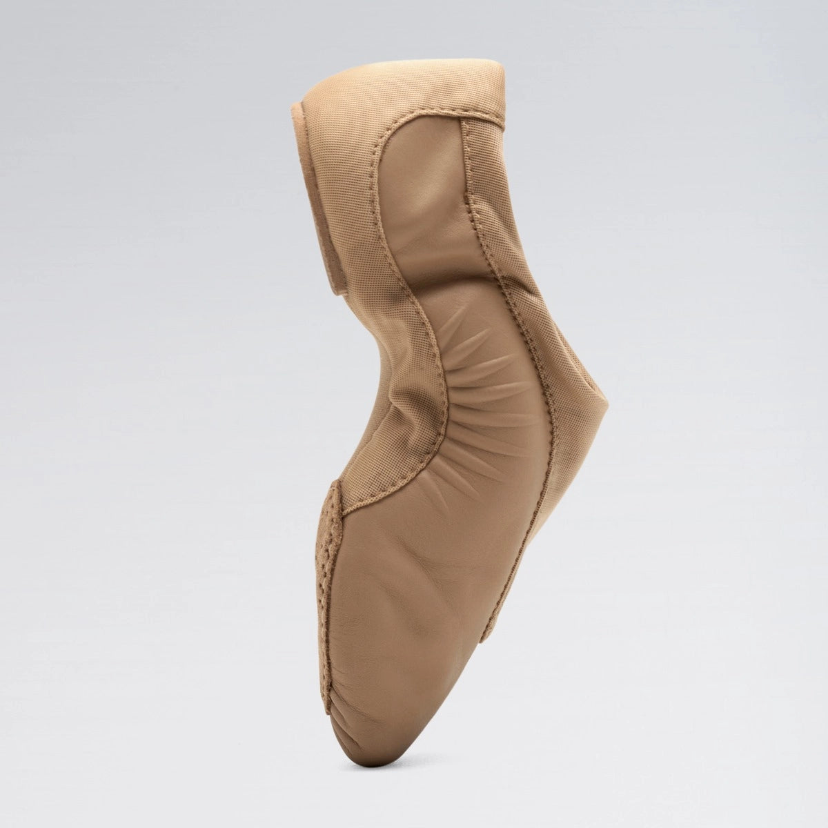 Tan ballet shoe on a light gray background
