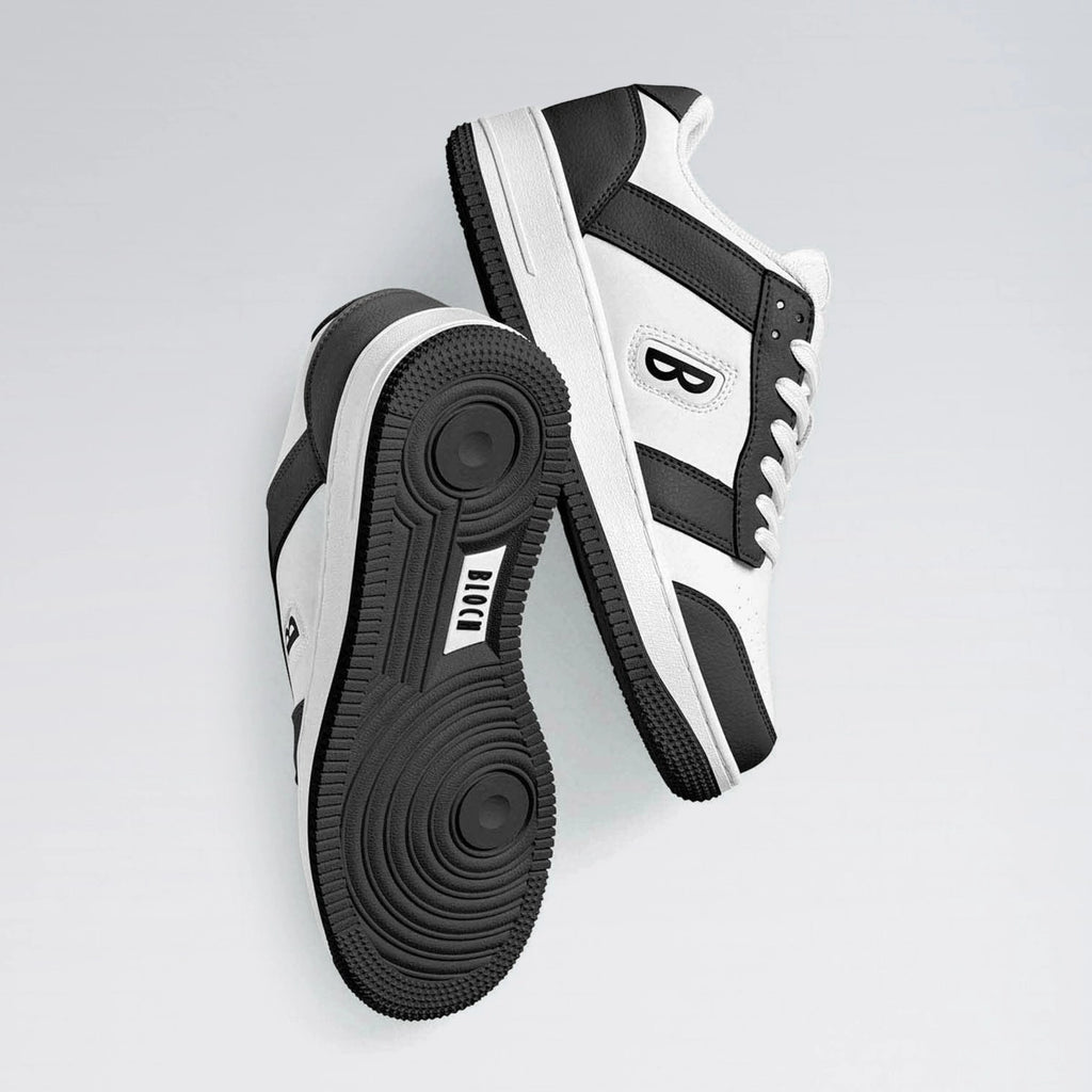 Black and white sneakers with a brand logo on a light gray background