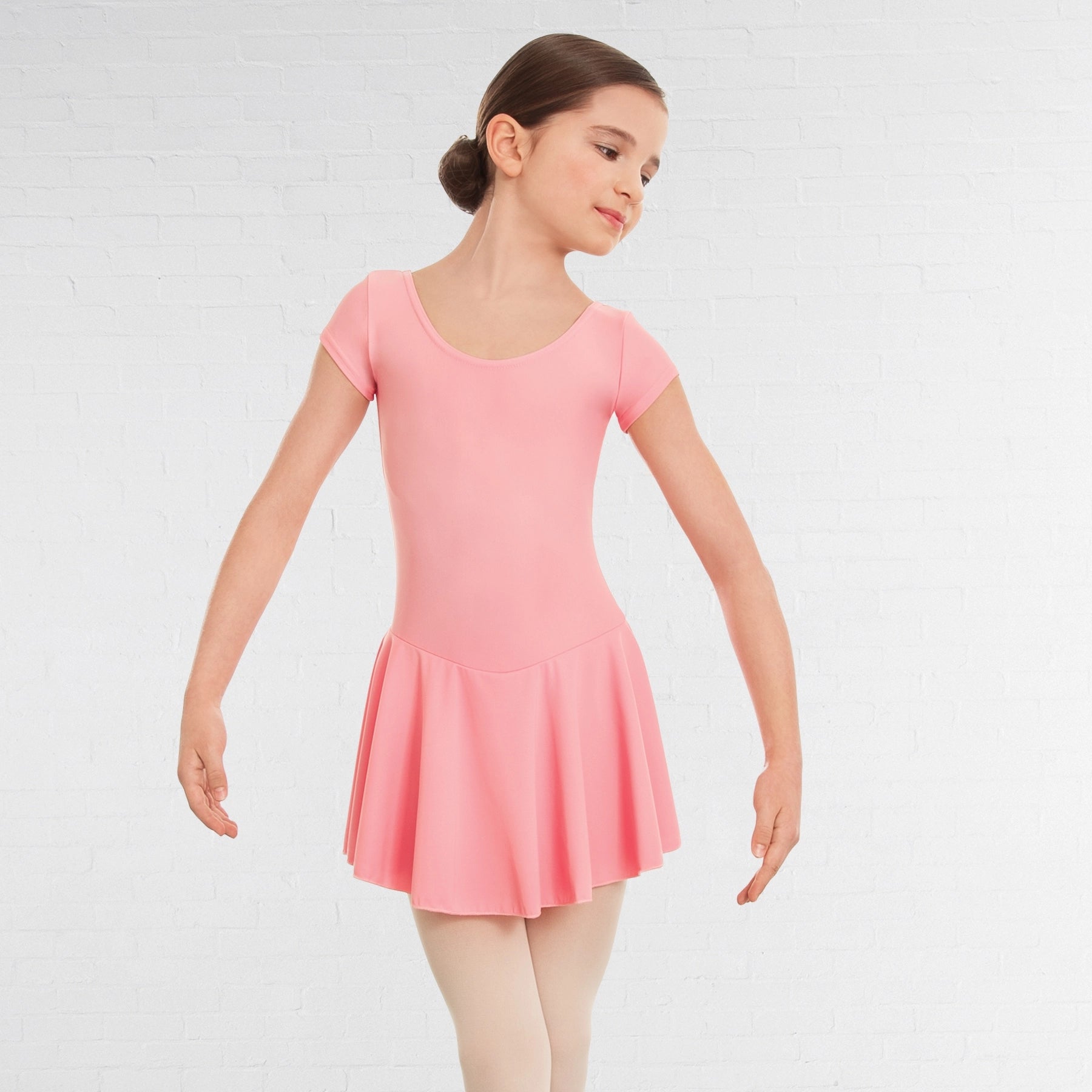 Young girl wearing a pink dress on a white background