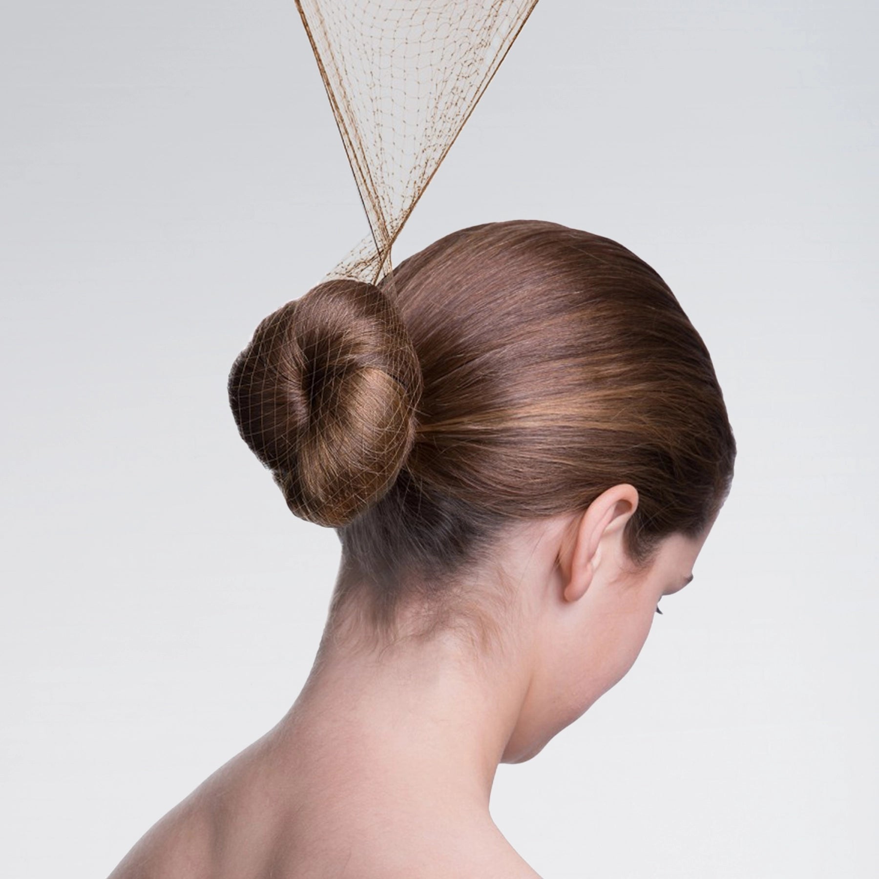 Woman with a stylish hair bun against a plain background
