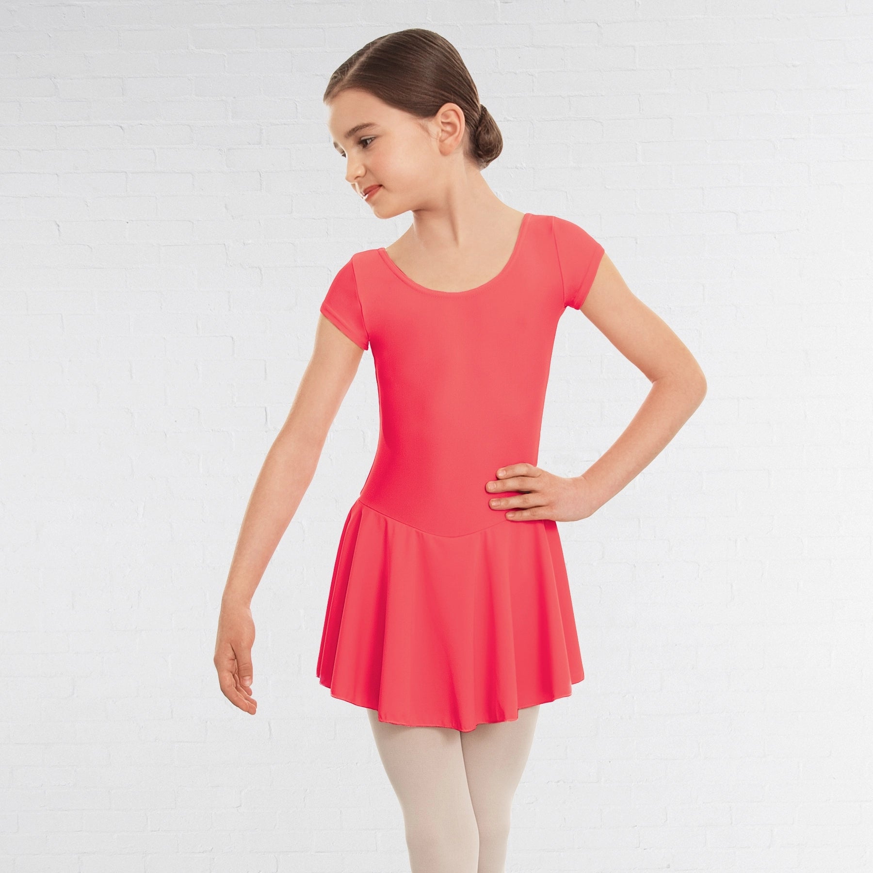 Young girl wearing a coral dress on a white background