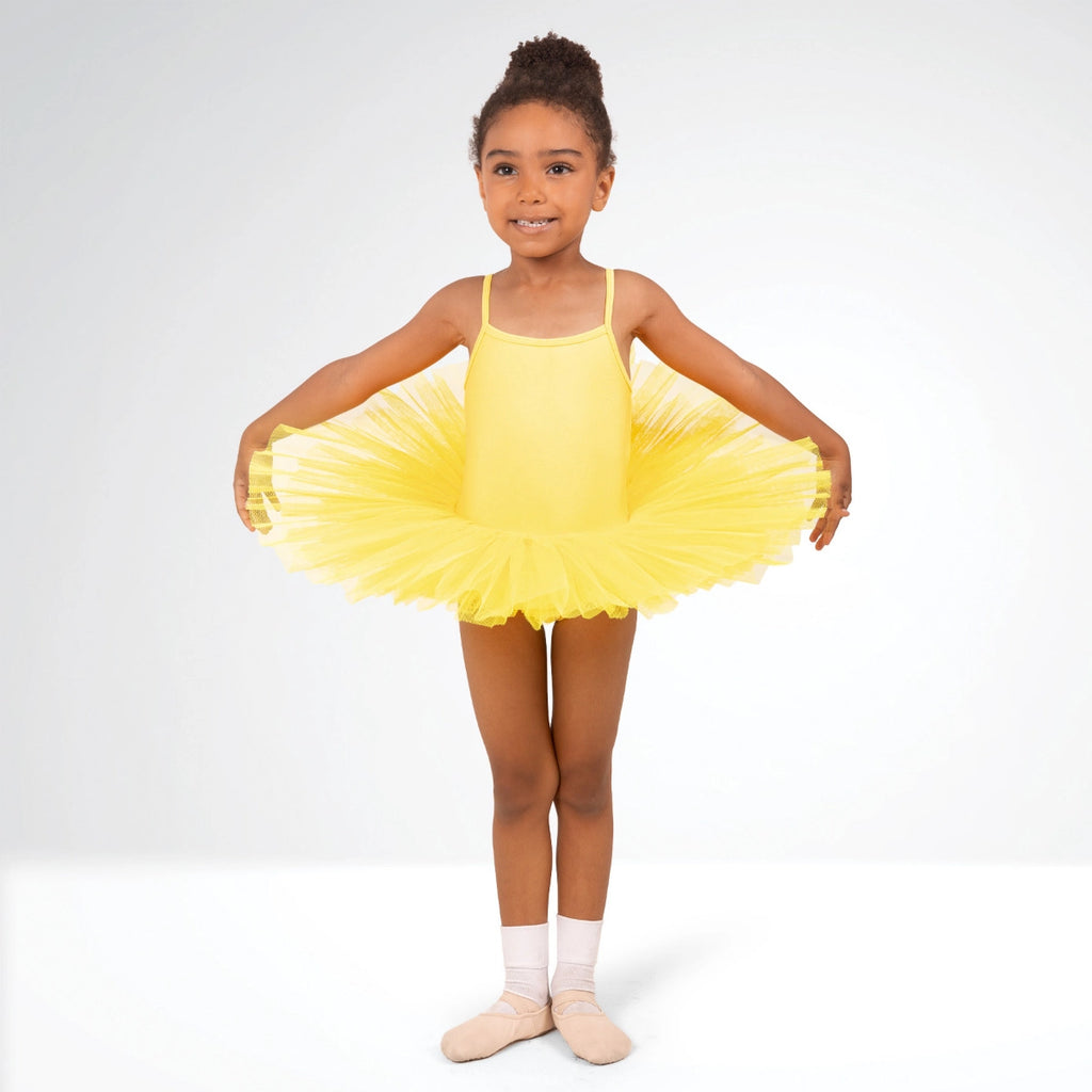 Young girl in a yellow tutu dress posing against a white background