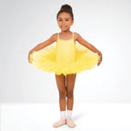 Young girl in a yellow tutu dress posing against a white background