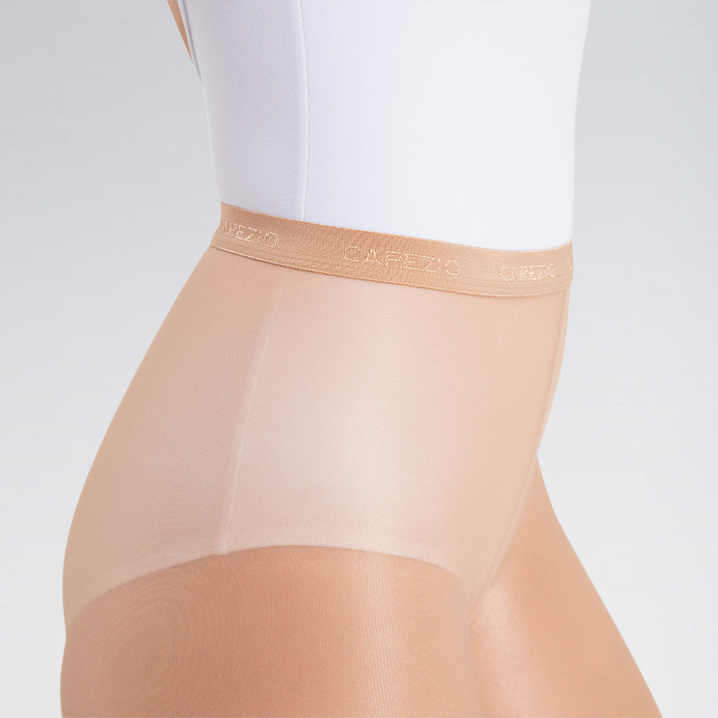 Beige shapewear worn over a white top on a light gray background