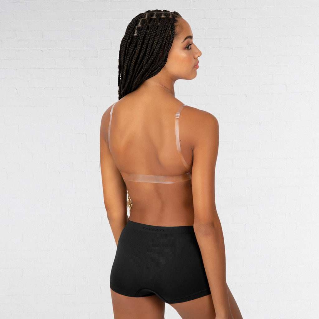 Woman wearing a transparent bra and black shorts on a white background