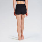 Person wearing black high-waisted shorts on a plain background