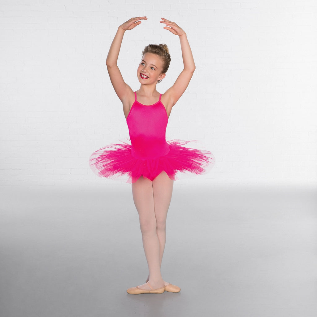 Young girl in a pink ballet outfit posing against a white background