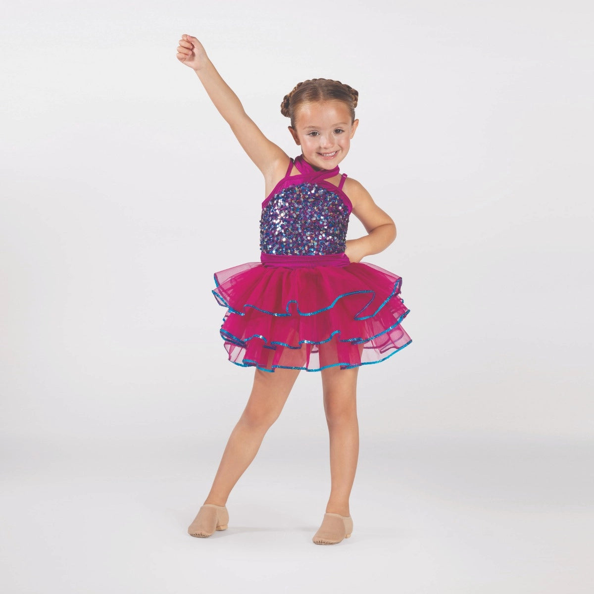 Young dancer wearing a raspberry pink sequin tutu costume by 1st Position featuring a crossover halterneck design, sparkling sequin bodice and layered tutu skirt with blue glitter trim.