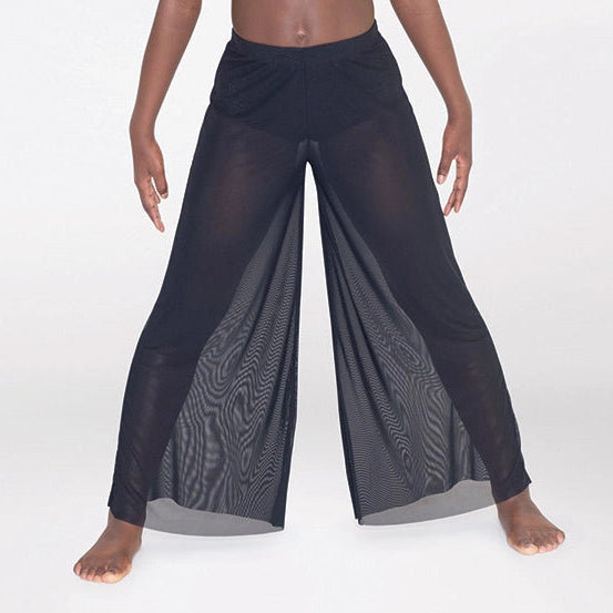 Woman wearing a pink top and black pants on a white background