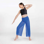 Woman wearing a black crop top and blue pants on a white background