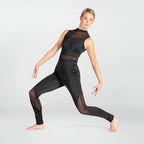 A woman modeling a black sleeveless athletic jumpsuit with sheer mesh panels on the chest and upper thighs, posed in a lunge against a light gray studio background.