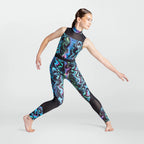 A girl in a sleeveless mock-neck athletic jumpsuit with a colorful abstract swirl pattern and black mesh panels, posing in a yoga or dance pose against a light gray background.