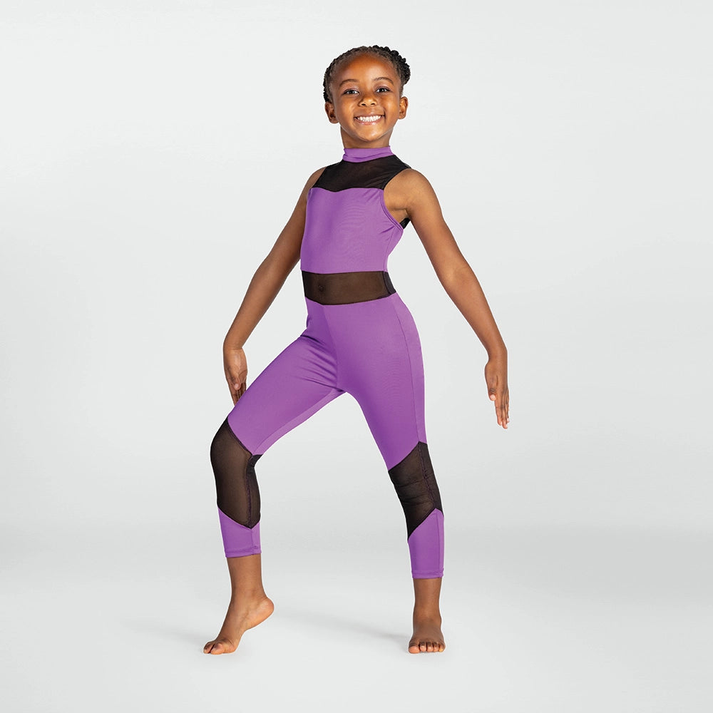 A young girl modeling a purple dance leotard with black mesh panels on a light gray studio background.