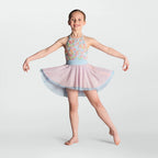 A young girl dancer posing in a sleeveless halter leotard with a pastel floral bodice, a light blue waistband, and a layered light pink and blue tutu skirt, set against a solid light gray background.