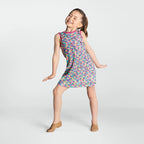 Young girl wearing a colorful patterned dress on a white background